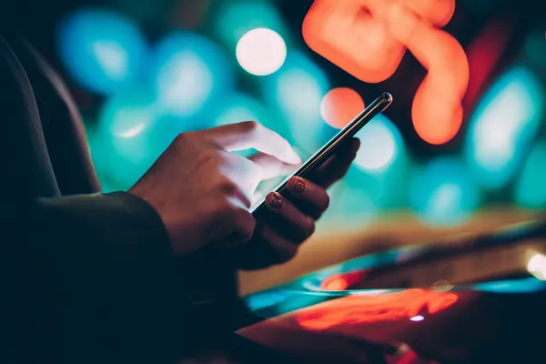Neon ışıklarla aydınlatılmış ortamda casino fişleri tutan şık bir kadın, PARA BET’ün premium online casino atmosferini temsil eder.