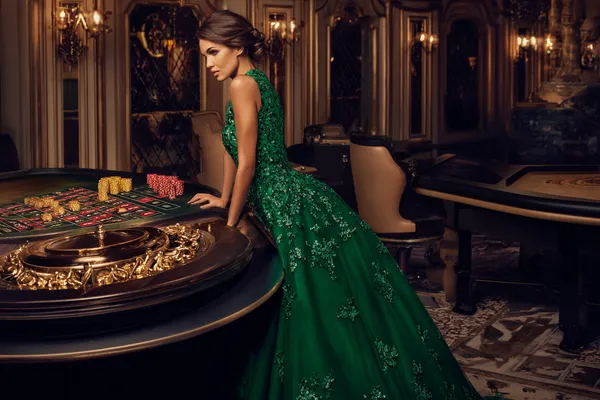 Lüks bir yeşil elbise giymiş bir kadın ve süslü bir rulet çarkı, PARA BET’ün üst düzey casino atmosferini yansıtır.